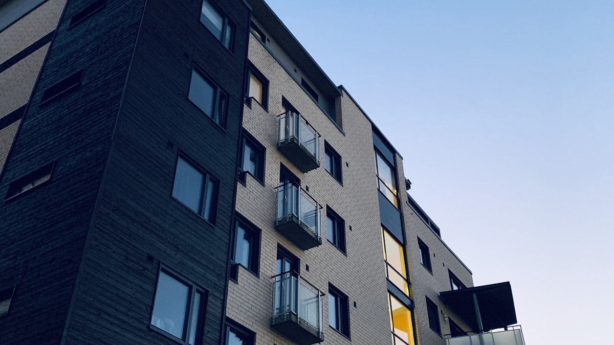 Immeuble d'habitation en brique claire avec balcons, au moment de choisir le type de bien où investir