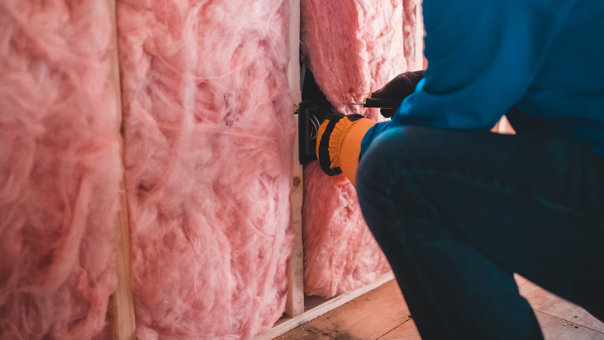 Pose de laine de verre isolante pendant une rénovation énergétique pour sortir du statut de passoire thermique